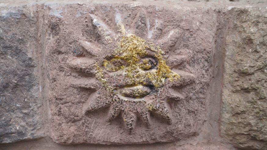 Знак солнца на каменной стене в Куско