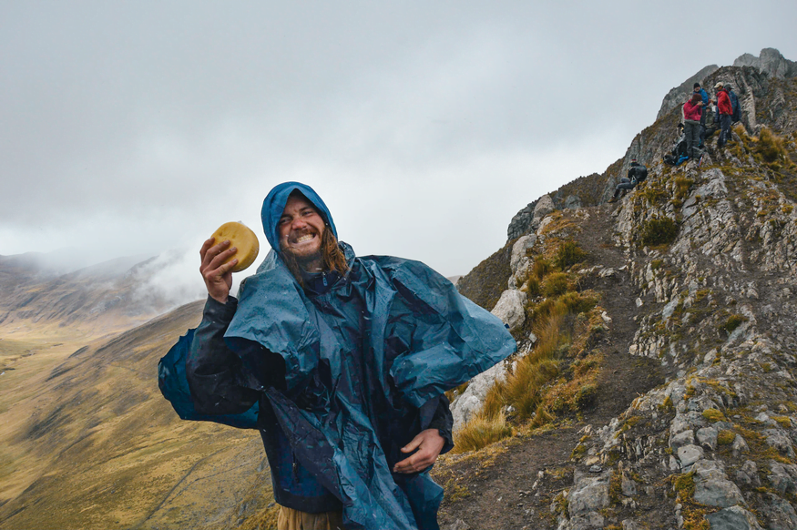 Парень держит сыр в походе в горах Перу