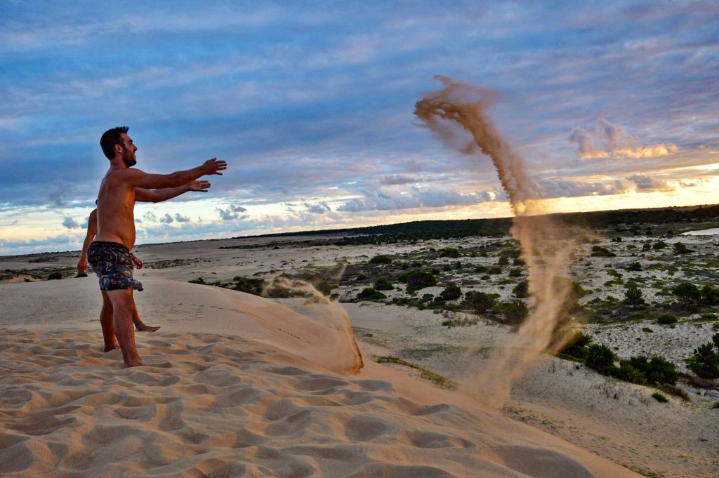 Мужчина бросает песок в воздух