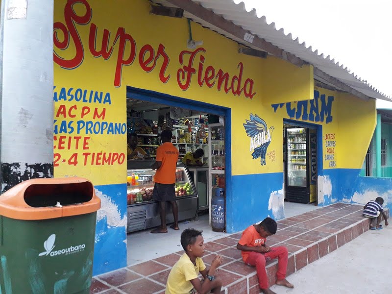 дети сидят у магазина с испанскими надписями