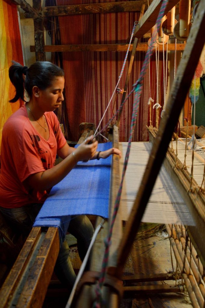 Женщина работает за ткацким станком 