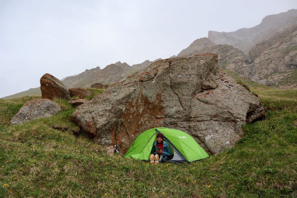 зеленая палатка у камня