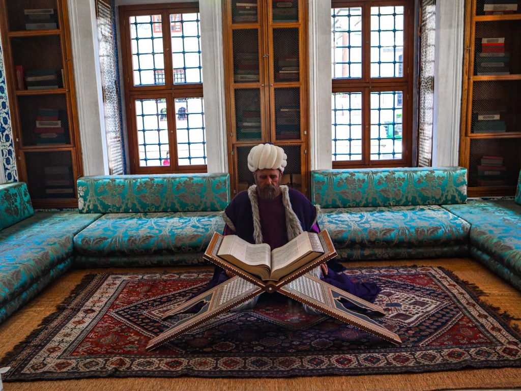 турок читает книгу в библиотеке