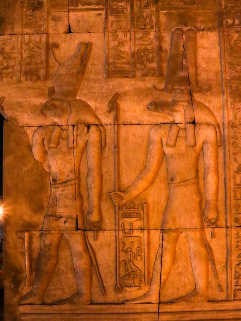 рельефы на старинной постройке в виде египетских богов