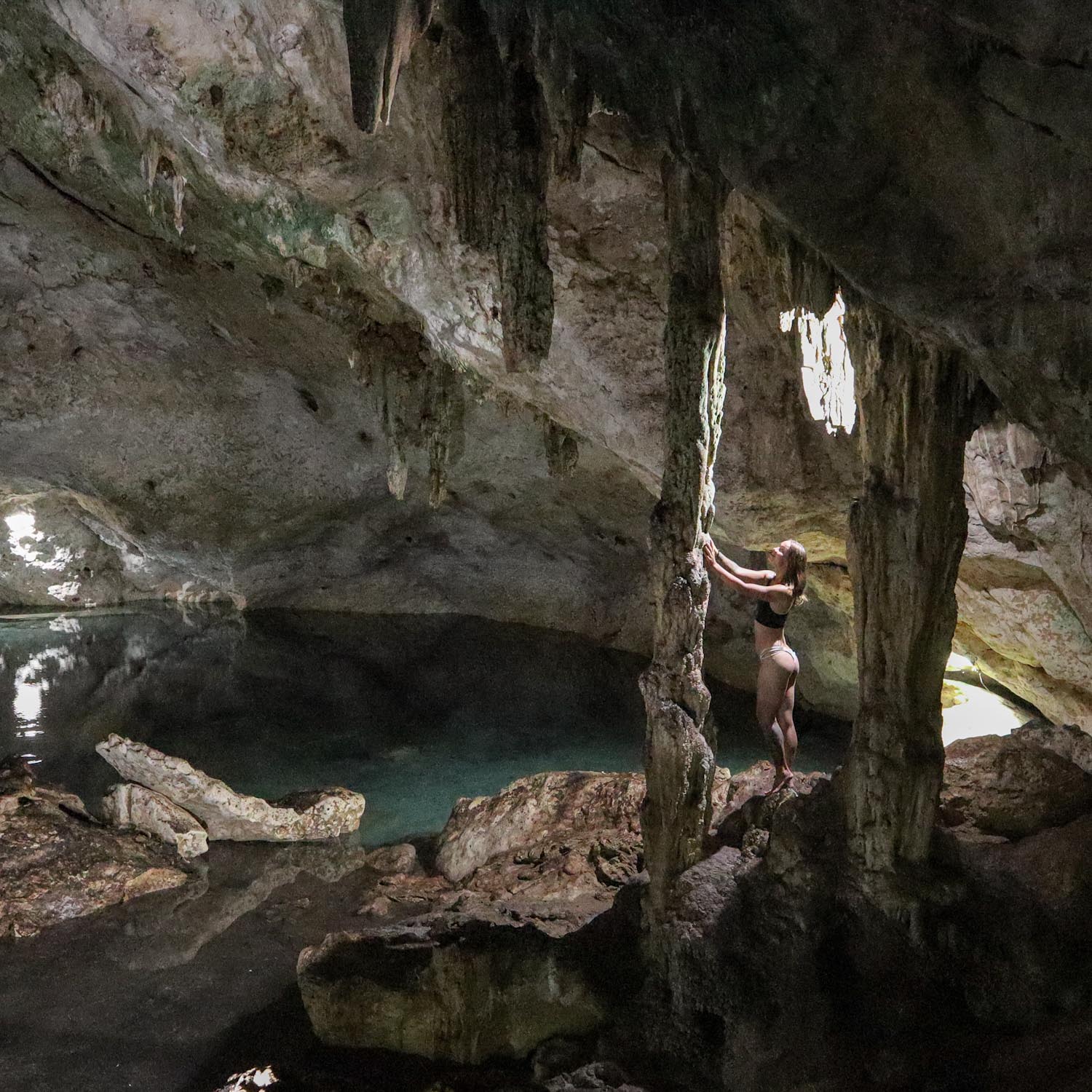 Девушка трогает сталагмит в пещере