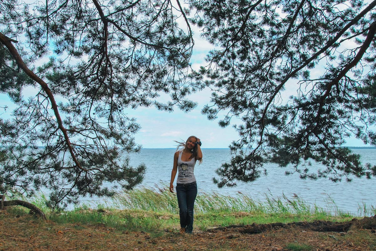 Девушка в обрамлерии сосновых веток у озера Нарочь в путешествие по Беларуси