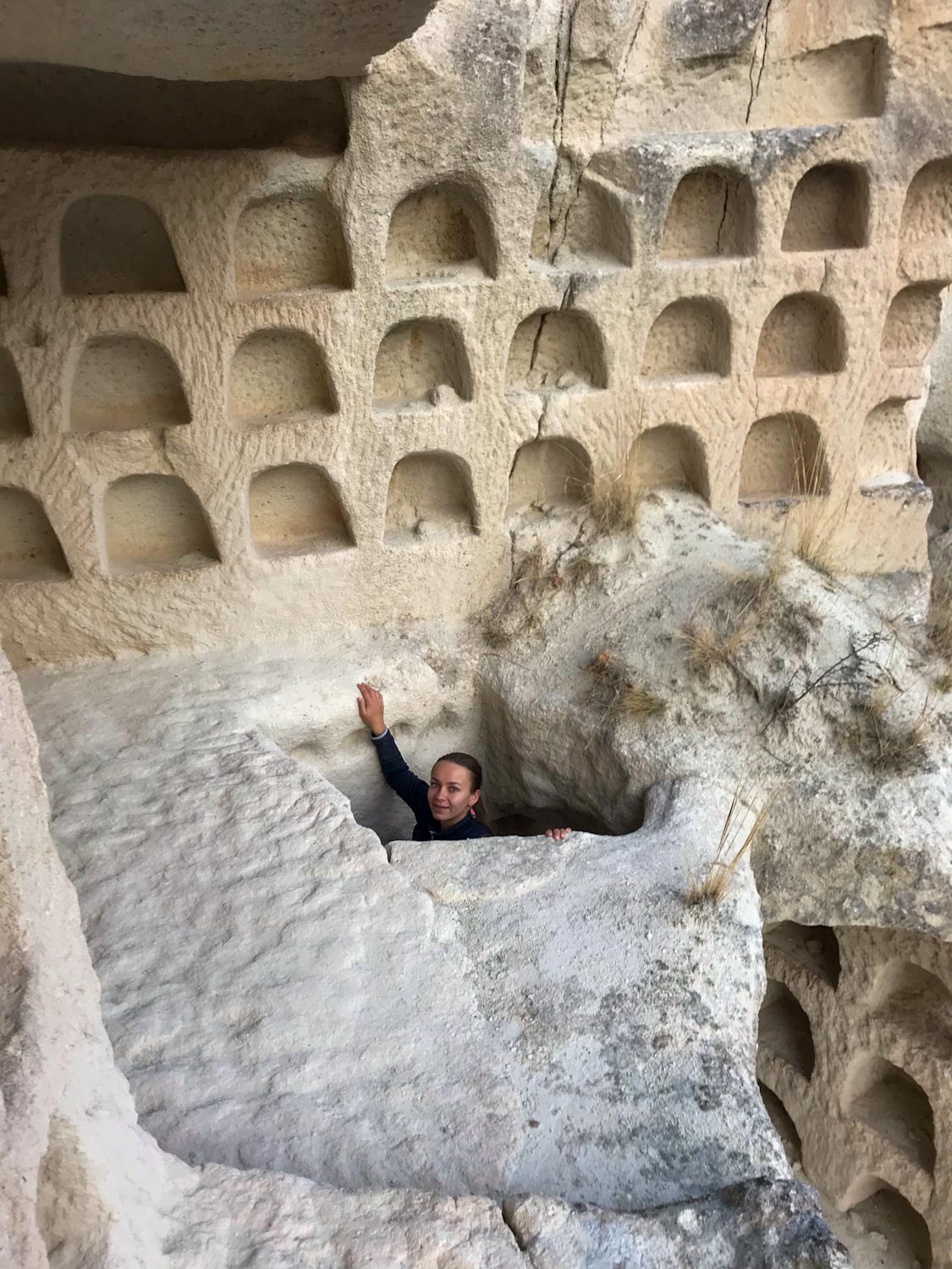 Девушка поднимается по вертикальному тоннелю — поход по долинам Каппадокии