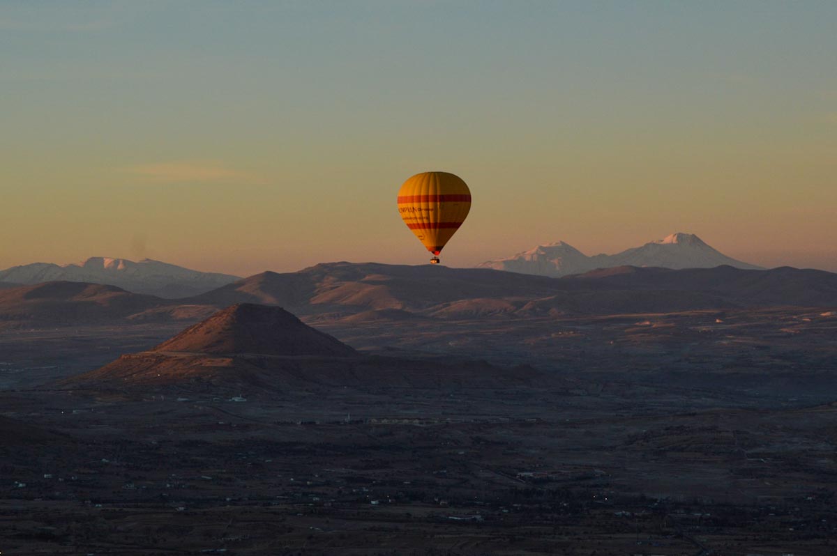 Вид на заснеженную горную вершину и воздушный шар — полет на воздушном шаре в Каппадокии