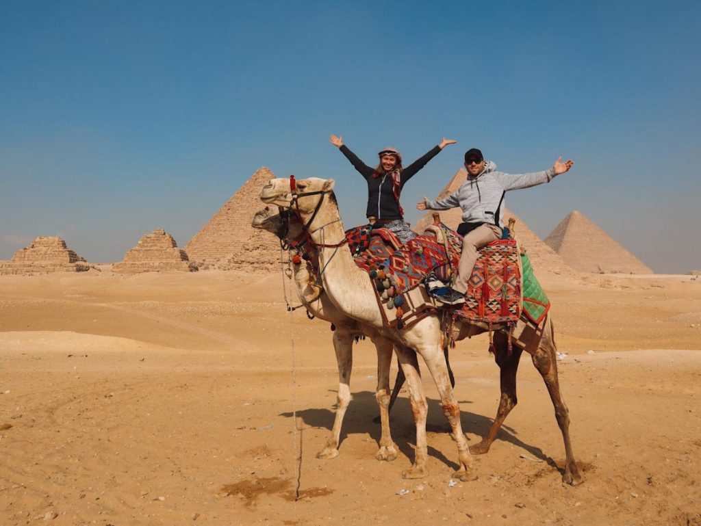 Туристы на верблюдах на фоне пирамид в Гизе