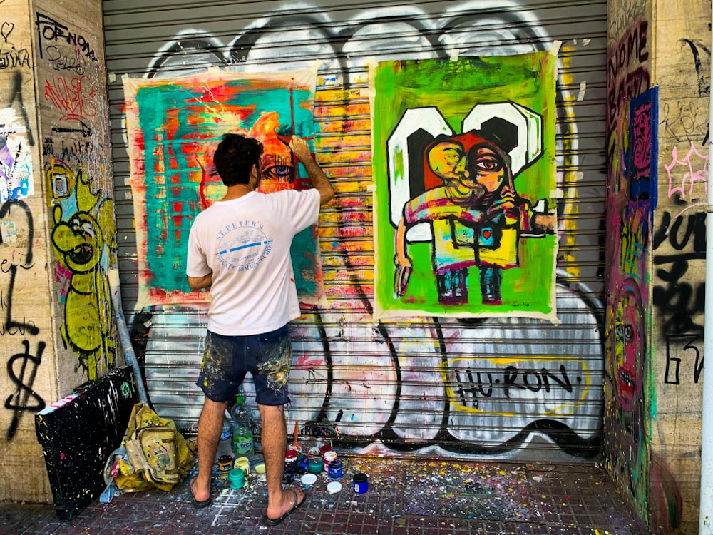 Мужчина рисует на стене красками
