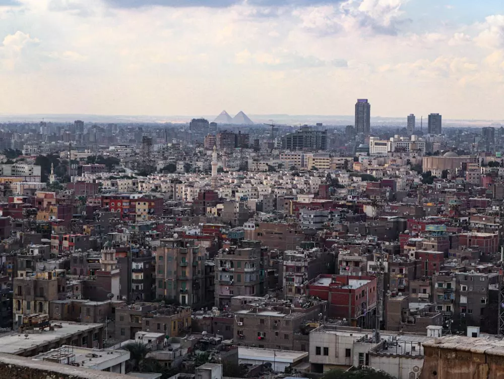 Панорама городской застройки с пирамидами на заднем плане — Каир