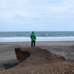 Мужчина смотрит на море на диком пляже