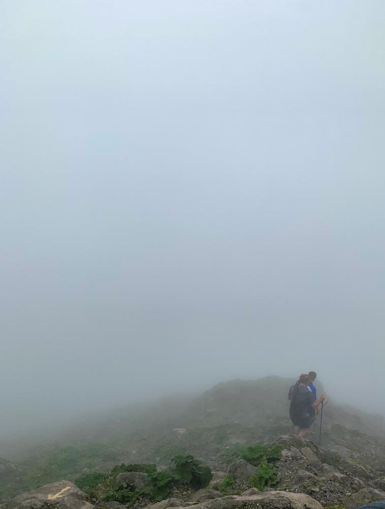 Люди спускаются с горы в тумане