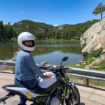 девушка на мотоцикле на фоне озера