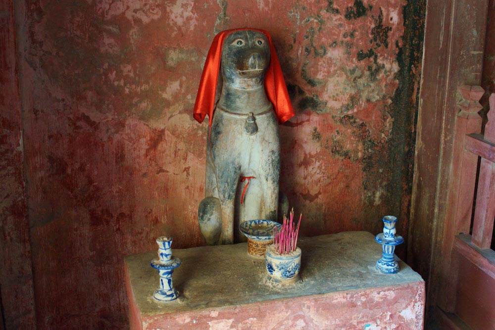 Статуя собаки в красном платке в храме Вьетнама