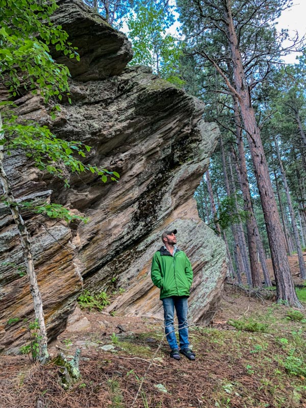 Мужчина позирует у скалы — Южная Дакота