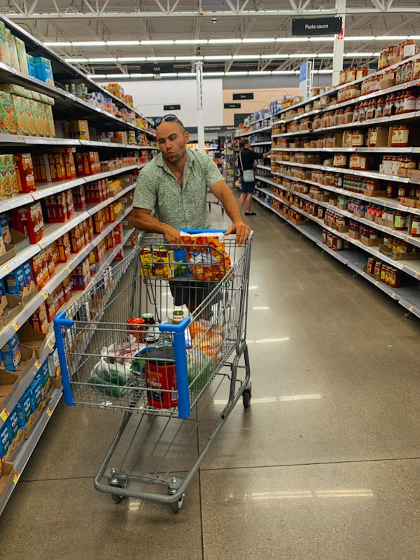Мужчина с тележкой в супермаркете