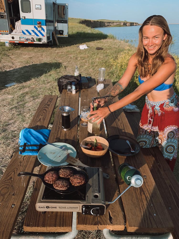 Девушка готовит еду в кемпинге — путешествие в автодоме по США