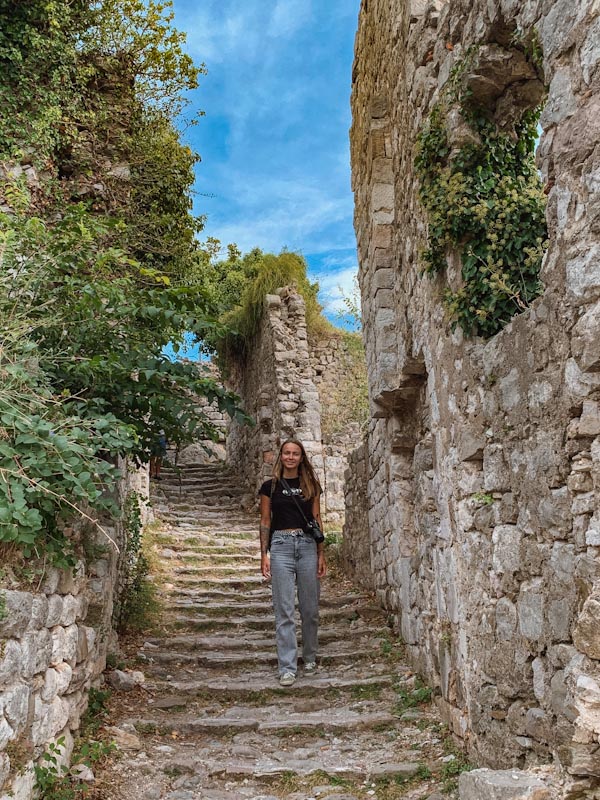 Девушка спускается по каменной лестнице в городе Старый Бар