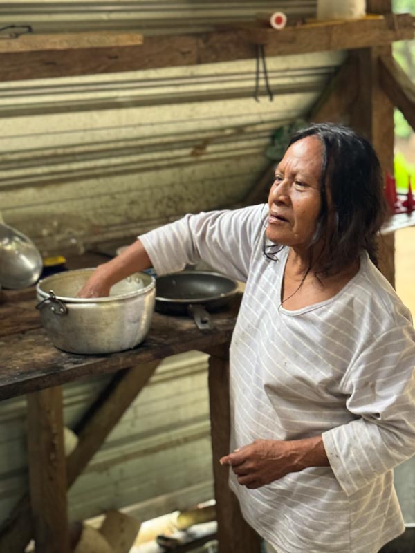 Waorani woman mixing chonta drink with her hand / Женщина ваорани размешивает рукой кашу в кастрюле